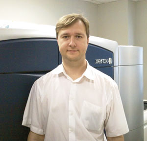 Представитель компании Xerox Дмитрий Славинский на фоне цифровой печатной машины Xerox Color 1000