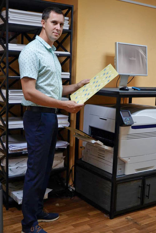 Директор компании 24print.by Андрей Борисов оценивает образцы отпечатков, сделанных на принтере OKI Pro9542dn